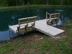 two wooden benches sitting on top of a pier next to a body of water with trees in the background