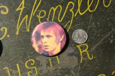 a close up of a person's face on a wall with writing and a coin