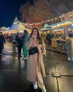 a woman standing in front of an open air market at night with her mouth open