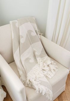 a white chair with a blanket on top of it