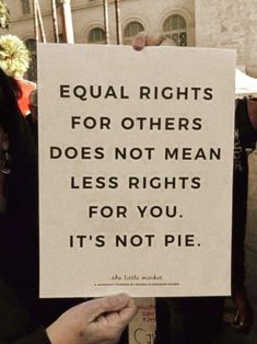 a woman holding up a sign that says equal rights for others does not mean less rights for you, it's not pie