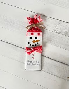 a red and white christmas ornament with a snowman on it