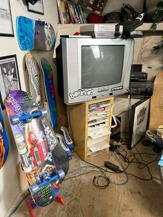 a tv and skateboards in a cluttered room