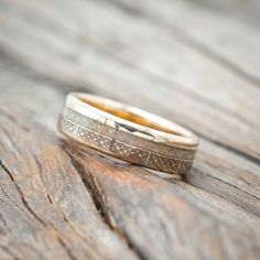 two wedding bands sitting on top of a wooden table