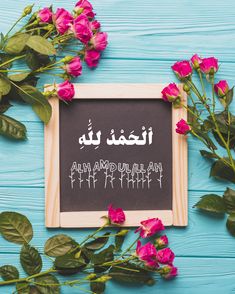 pink roses are next to a chalkboard with the words alham amu'aah written in arabic