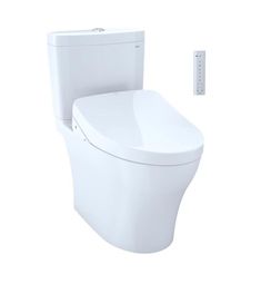 a white toilet sitting next to a remote control