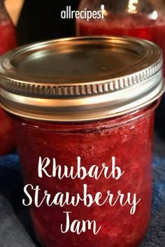 a jar filled with rhubarb strawberry jam on top of a blue towel