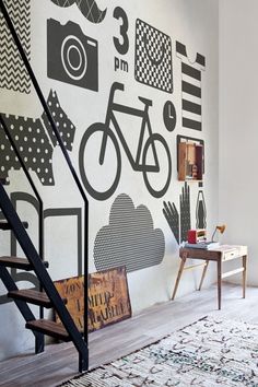 a room with a stair case, rug and painting on the wall next to it