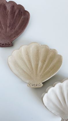 three ceramic seashells with names on them