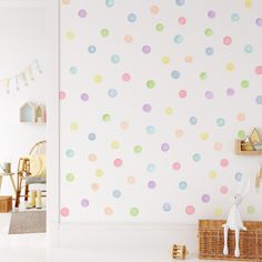 a child's room decorated in pastel colors with polka dots on the wall