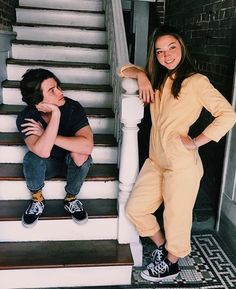 two young women standing on the steps of a house