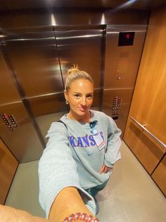 a woman is sitting on the floor in an elevator