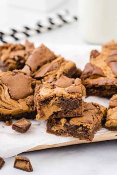 chocolate brownies with peanut butter frosting on a cutting board next to a glass of milk