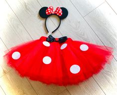 a red and white minnie mouse tutu with a black bow on it's head