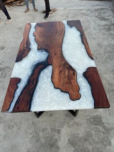 a table made out of wood with white and blue paint on it, sitting in the middle of a warehouse floor