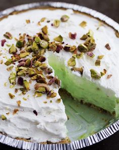 there is a pie with white frosting and pistachios on the top