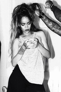 a black and white photo of a woman getting her hair done by a man with tattoos on his arm