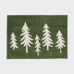 a green rug with white pine trees on the front and bottom, in two rows