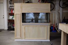 a large wooden cabinet sitting inside of a garage next to a bike rack and shelves