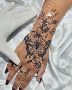 a woman's hand with a butterfly tattoo on it