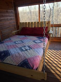 a bed with a quilt on it in a cabin