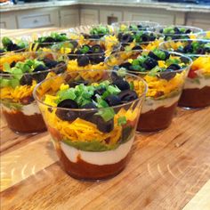 several cups filled with food sitting on top of a wooden table