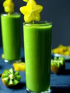 two glasses filled with green smoothie on top of a table