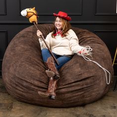 a woman is sitting on a bean bag chair with a toy horse attached to it