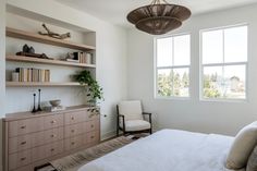 a bedroom with white walls and wooden furniture