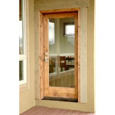 an open wooden door on the outside of a house with wood flooring and windows