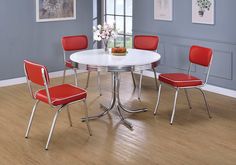 a white table with four red chairs around it