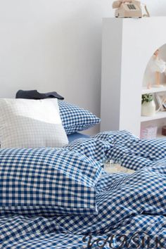 a blue and white checkered comforter on a bed