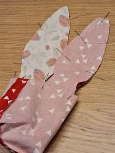 two pieces of fabric sitting on top of a wooden table