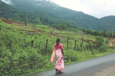 a woman is walking down the road with her pink sari