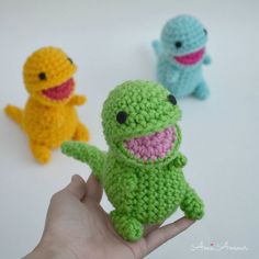 three small crocheted toys in the shape of animals are being held by someone's hand