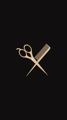 a pair of scissors and a comb on a black background