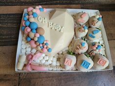 a heart shaped cake in a box with marshmallows and other candies