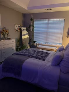 a bedroom with a bed, dresser and window