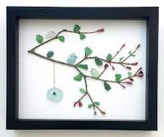 a shadow frame with some leaves and a bird on it's back hanging from the wall