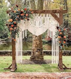 an outdoor wedding ceremony with macrami and flowers on the arbor, hanging from a tree