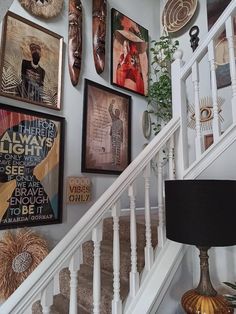 there are many pictures on the wall above the stairs