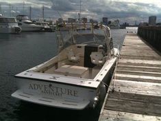 a white boat is docked at the dock