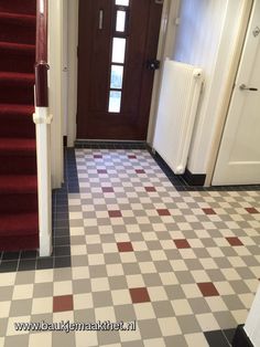 a hallway with red and white checkered flooring next to a brown wooden door