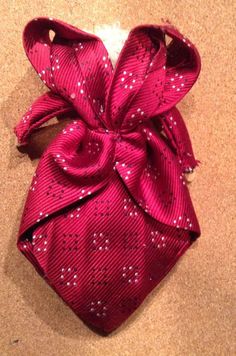 a red tie with white dots on it sitting on the ground next to a wall