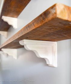 two wooden shelves on the wall with white trim