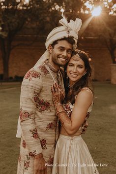 a man and woman standing next to each other in front of the sun on their wedding day