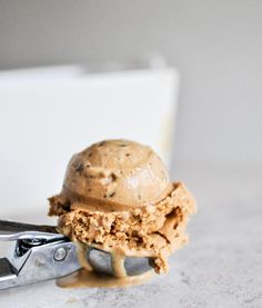 a scoop of ice cream sitting on top of a pair of tongs