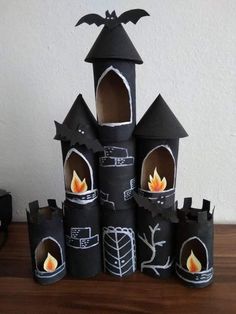 some sort of castle made out of toilet paper with a candle in the middle and bats on top