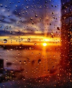 the sun is shining through raindrops on a window