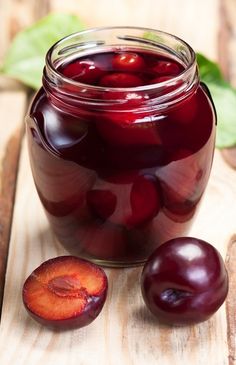 plums in a glass jar on a wooden table